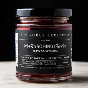 Top Shelf Preserves Maraschino Cherries jar on marble surface with black background